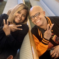 two people smiling holding peace signs